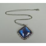 A 1920s SILVER PENDANT & NECKLACE with iridescent butterfly-wing under domed glass, marked 'silver'