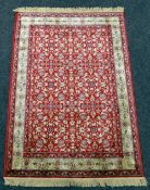 RED GROUND KASHMIR RUG with all over floral design with gold boarder, 136 x 194cms