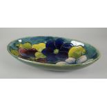 A MOORCROFT POTTERY OVAL DISH in the 'Clematis' pattern with tube-lined flowers to a green ground,