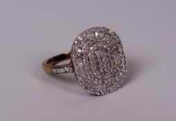 A DIAMOND CLUSTER RING the diamonds in an oval with diamonds to the shoulders set to 9ct yellow gold