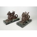 A PAIR OF BRONZE GRYPHON SPILL VASES on rectangular veined marble bases, 14cms wide