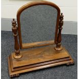 A VICTORIAN MAHOGANY TOILET MIRROR with arched glass frame swivelling on fluted & carved supports