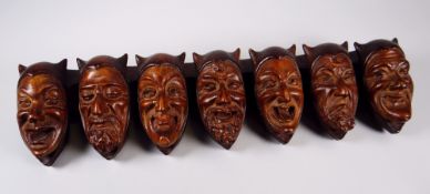 AN UNUSUAL CONTINENTAL CARVED TREEN MOUNTED STICK-STAND in the form of a series of horned Satanic
