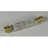 A VICTORIAN FACETED CLEAR GLASS DOUBLE-END SCENT BOTTLE with hinging yellow metal lids and collars,