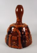 AN INTERESTING SLIPWARE BELL-SHAPED DECANTER with unusual applied symbols including skull and
