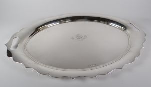 AN OVAL SILVER TRAY having twin open handles within the raised ogee border, engraved with a centre