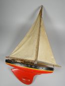 A VINTAGE PAINTED WOODEN POND YACHT with canvas sails, 61cms high