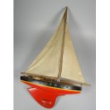 A VINTAGE PAINTED WOODEN POND YACHT with canvas sails, 61cms high