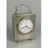 A SILVER BEDROOM CLOCK with fine machine-turned encasement, circular white dial bearing Arabic