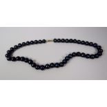 A STRAND OF BLACK PEARLS with 9ct hallmarked gold clasp, 42cms long