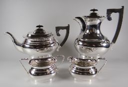 A FOUR PIECE ELIZABETH II SILVER TEA-SERVICE of oval form with composite handles and knops,