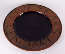 A STUDIO POTTERY CHARGER inscribed to the border 'TWENTY FIVE YEARS' potter's mark belived to be