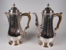 A PAIR OF BRITANNIA STANDARD SILVER COFFEE POTS in the Georgian style and having Bakelite type