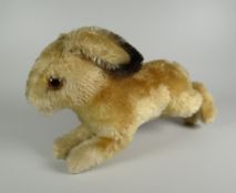 A STEIFF SOFT-TOY RABBIT in leaping pose and with glass eyes, label and stud to ear, 22cms long
