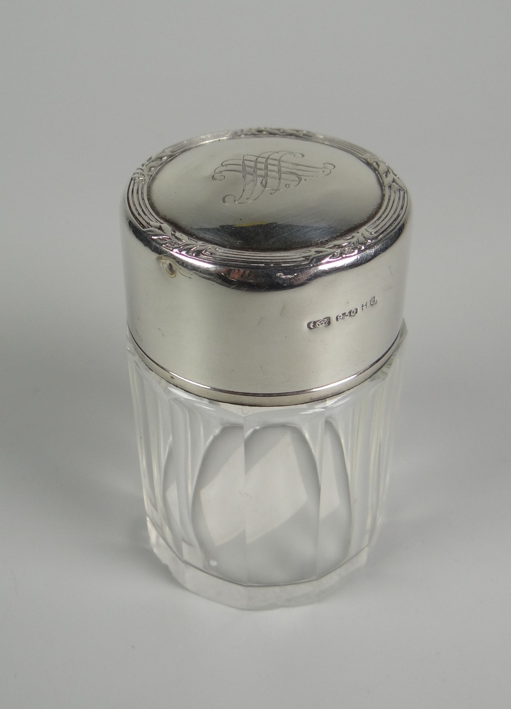 A FACETED GLASS & SILVER SCENT BOTTLE with original interior stopper, the silver lid with monogram