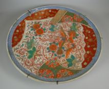 AN IMARI POTTERY CHARGER typically decorated with blue border and exotic flora and fauna, 46cms