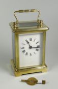AN ENGLISH MADE BRASS CASED CARRIAGE CLOCK having a white enamel dial with Roman numerals, 15cms