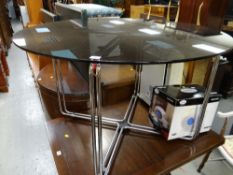 A smoky glass circular studio dining table on chrome supports
