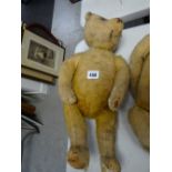 A vintage straw stuffed teddy bear with head movement by turning the the tail