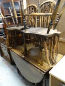 An antique oak gateleg dining table & four wheel back chairs