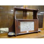 A vintage wall hanging smoker's cabinet with carved door