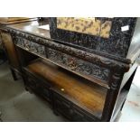 An antique carved two-drawer buffet sideboard