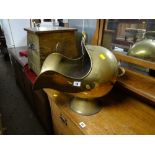 A brass helmet coal scuttle