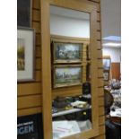 A modern lightwood framed hall mirror