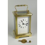 AN ENGLISH MADE BRASS CASED CARRIAGE CLOCK having a white enamel dial with Roman numerals, 15cms