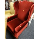 A red velvet upholstered wingback armchair