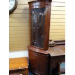 A reproduction mahogany glazed top standing corner cupboard