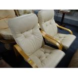 A pair of modern lightwood framed cream leather cushioned armchairs