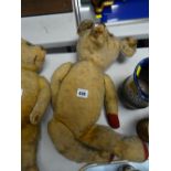 A vintage store stuffed teddy bear with the head moving left to right & with red paw pads
