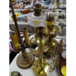 A brass & clear glass oil lamp base together with another brass oil lamp base, brass table lamp