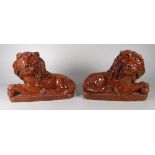 A PAIR OF RARE OBLONG BASED GLAZED TERRACOTTA PIL RECLINING LIONS, 23cms long (believed to be by