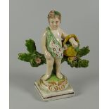 A RARE SWANSEA CAMBRIAN POTTERY PUTTO circa 1810-1815 flower picking while standing against a floral