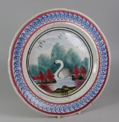 A RARE LLANELLY PLATE with sponged decoration of a swan between gates and with trees and birds,