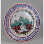 A RARE LLANELLY PLATE with sponged decoration of a swan between gates and with trees and birds,