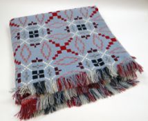 A WELSH WOOL BLANKET in bird's egg blue ground with black, burgundy and white geometric pattern
