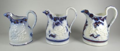 A TRIO OF YNYSMEUDWY LUSTRE DECORATED JUGS (attributed to) near matching with relief decoration of