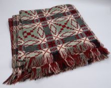 A WELSH WOOL BLANKET with green ground and black, burgundy and white geometric pattern and check