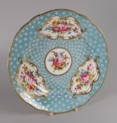 A NANTGARW PLATE of lobed form decorated with four panels of colourful flower sprays within gilded