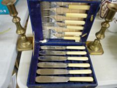 Cased set of bone handled fish cutlery and a pair of brass candlesticks