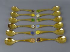 GEORGE JENSEN, DENMARK TWELVE SILVER GILT YEAR SPOONS with enamel floral decoration, dated 1971 to
