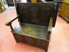 AN OAK BOX SEAT MONK'S BENCH with good linenfold carving to the panels, 100 cms high, 105 cms