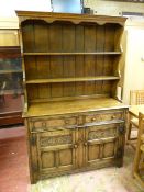A QUALITY REPRODUCTION OAK DRESSER with blind carved detail to the doors, 185 cms high, 122 cms