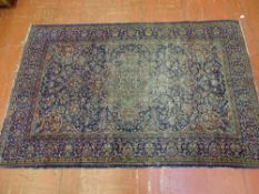 A WELL WORN EASTERN WOOLLEN CARPET predominantly blue ground with central design and continuous