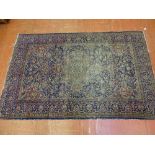 A WELL WORN EASTERN WOOLLEN CARPET predominantly blue ground with central design and continuous