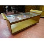 A G-PLAN GLASS TOPPED COFFEE TABLE with curved ends, 51 cms high overall, 121.5 cms wide, 51.5 cms