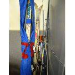 Two pairs of skis and poles and a fishing rod